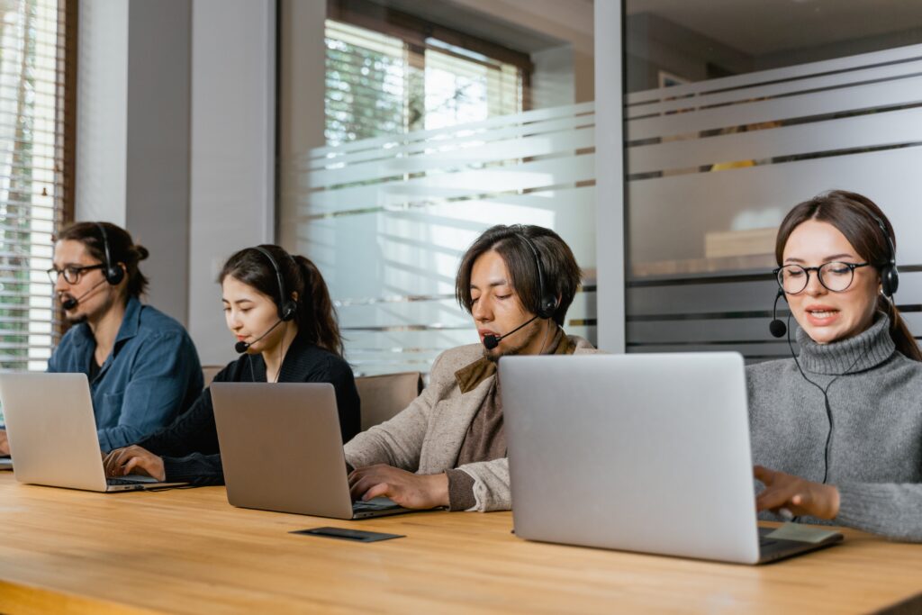 four receptionists on the phone with customers