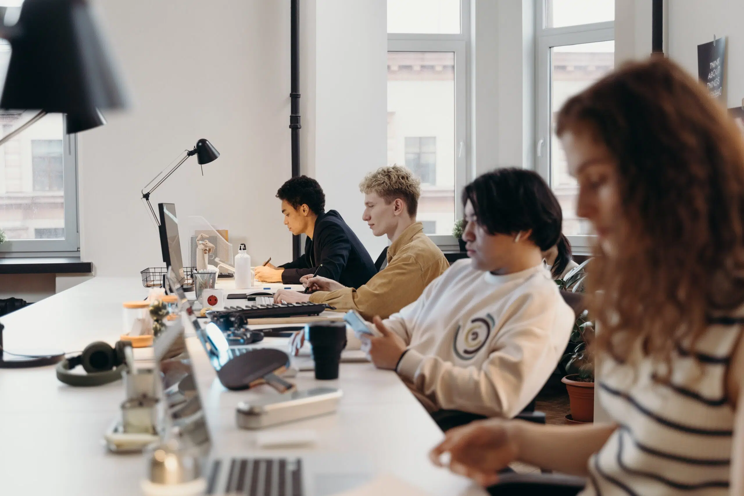 four receptionists on their laptops